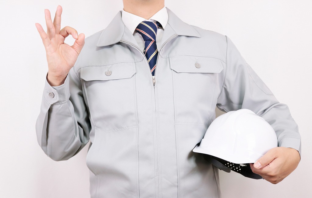 OKサインとする作業服の男性